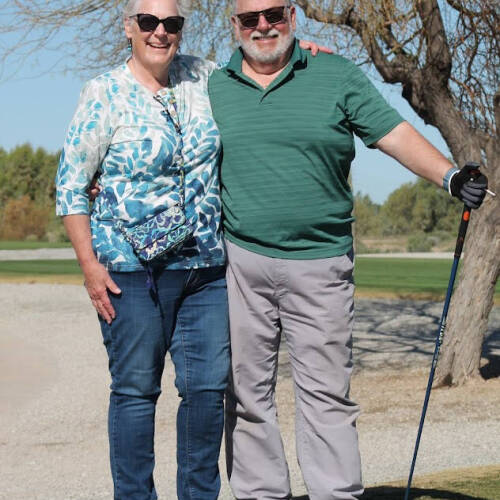 Phil and Susan Brunell posing for a photo while playing golf